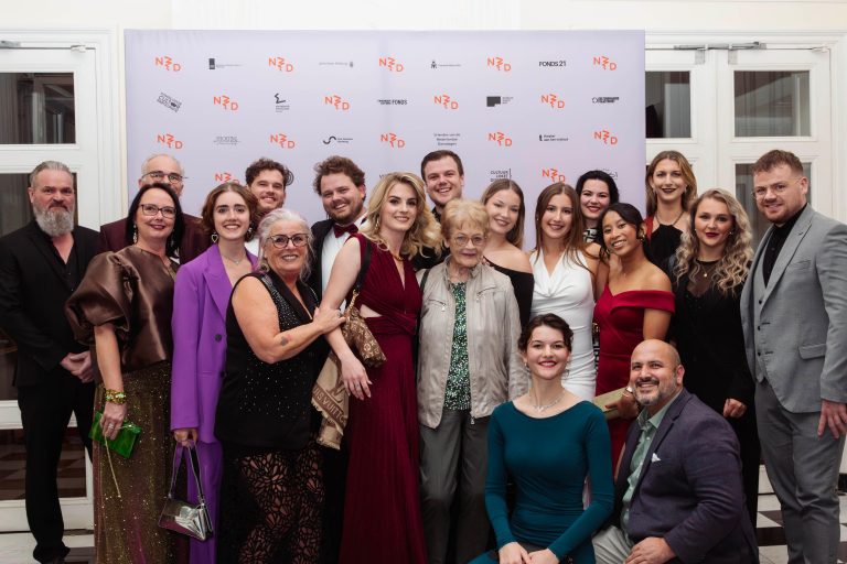 groepsfoto gala va de Nederlandse dansdagen, alle dansers, en hun familie staan voor het nederlandse dansdagen doek